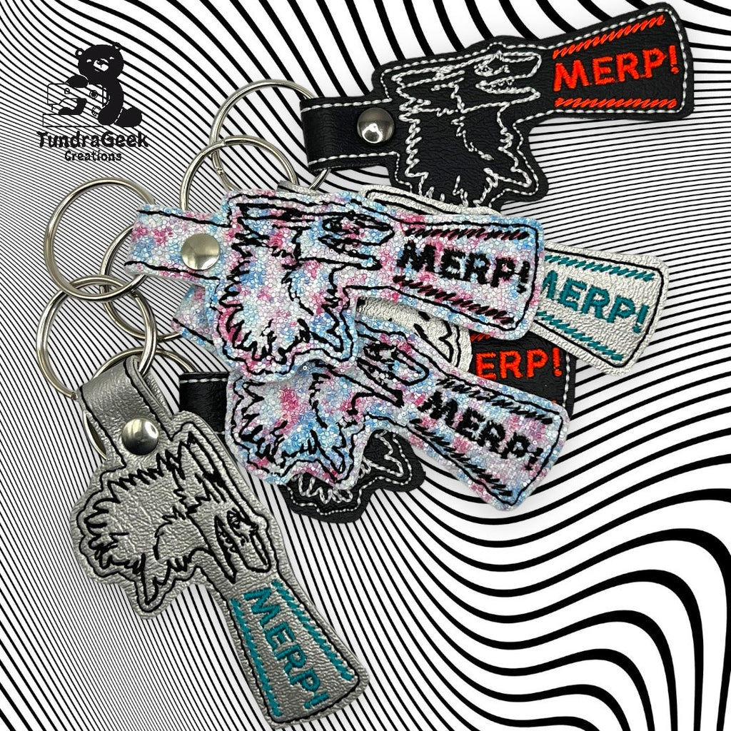 Several keychains shaped like a howling animals head, each embroidered with the word MERP! in different colors, are displayed on a black and white wavy background.