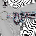 A keychain shaped like a hand making a finger gun with “NERP!” written on it, placed on a wavy black and white patterned background.