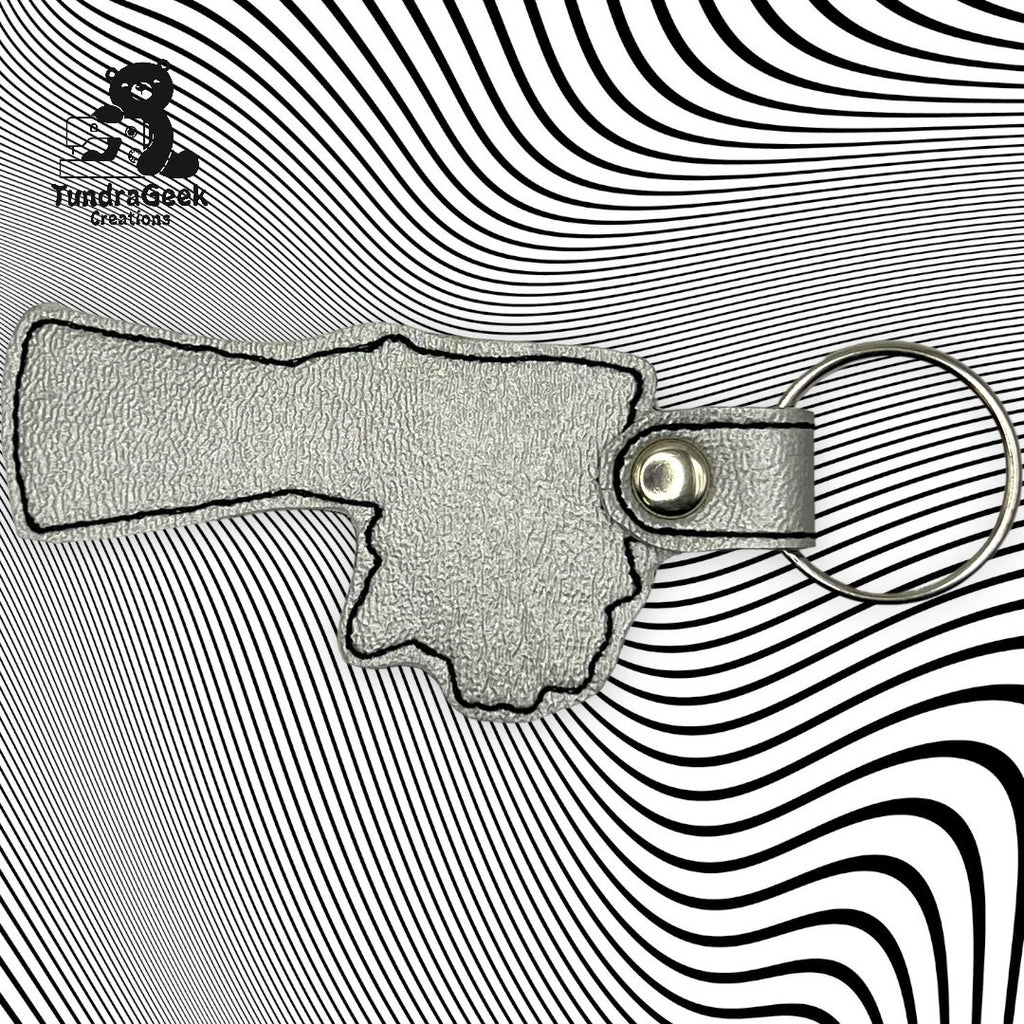 A textured leather keychain in the shape of a hand pointing right, placed on a black and white wavy line background.