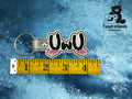 A keychain with UwU text and pink blush marks is placed next to a measuring tape showing it is about 3 inches long. The TundraGeek Creations logo appears in the top right corner.
