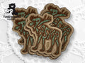 A group of embroidered patches displays the word Alaska integrated with evergreen tree designs, arranged on a textured white background. The TundraGear Creations logo is in the corner.