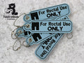 Four blue keychains with metal chains display the text For Rectal Use ONLY in black, with a logo reading TundraGeek Creations in the top left corner.