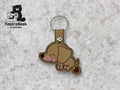 Tan and brown embroidered dachshund dog keychain with a snap closure on a light gray textured background. TundraGeek Creations logo is visible in the top left corner.