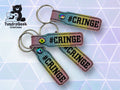 Three glittery keychains with the word #CRINGE printed on them, displayed on a geometric patterned background. TundraGeek Creations logo is in the top left corner.