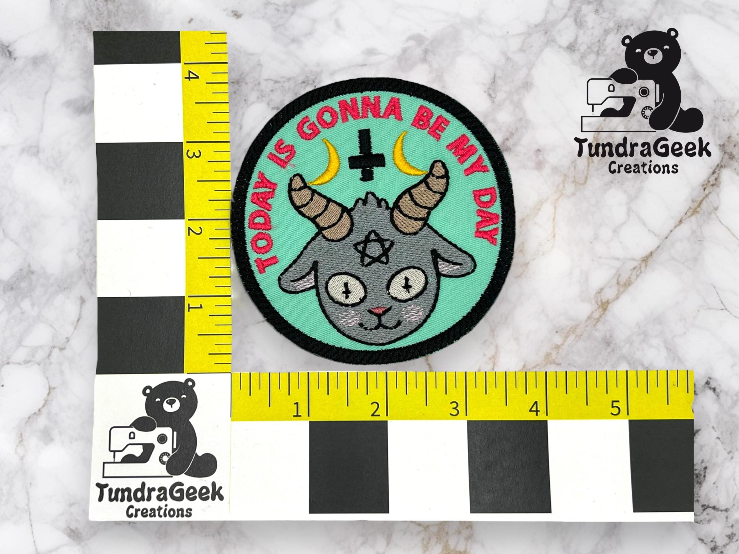 A circular patch with a goat head, pentagram, and crescent moon, with the text TODAY IS GONNA BE MY DAY on a turquoise background, next to rulers for scale.
