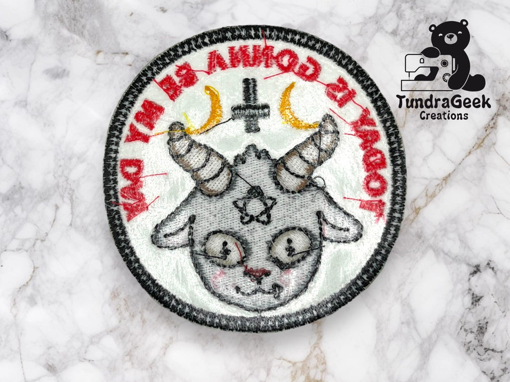 Embroidered patch featuring a cartoon goat with horns, crescent moons, and an inverted cross, with red text and TundraGeek Creations logo in the corner.
