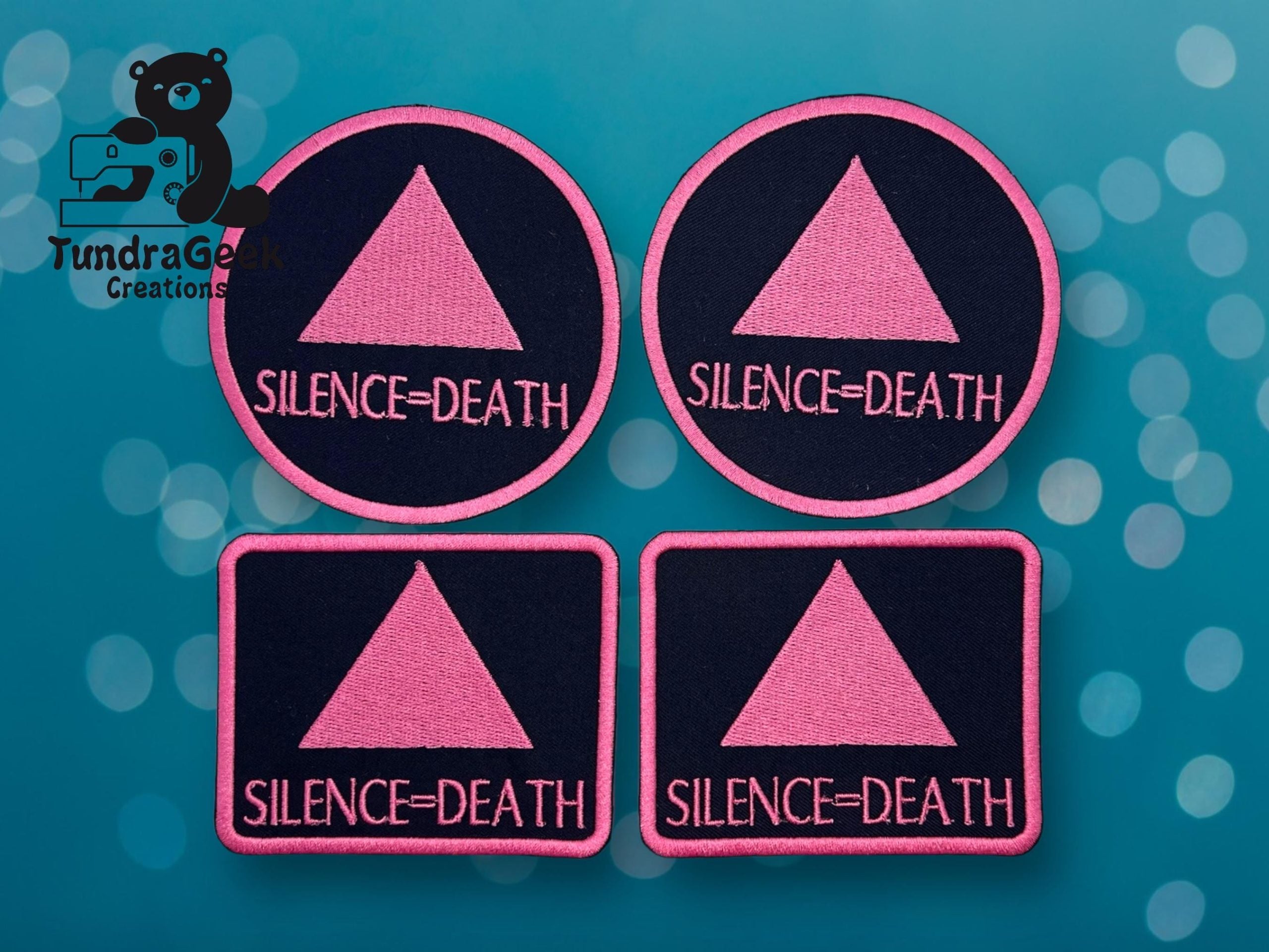 Four patches featuring a pink triangle and the words Silence = Death on a dark background, displayed on a blue, bokeh-effect surface.