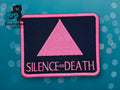 A rectangular patch with a pink triangle and the words SILENCE = DEATH in pink on a dark background, with the TundraGeek Creations logo in the upper left corner.