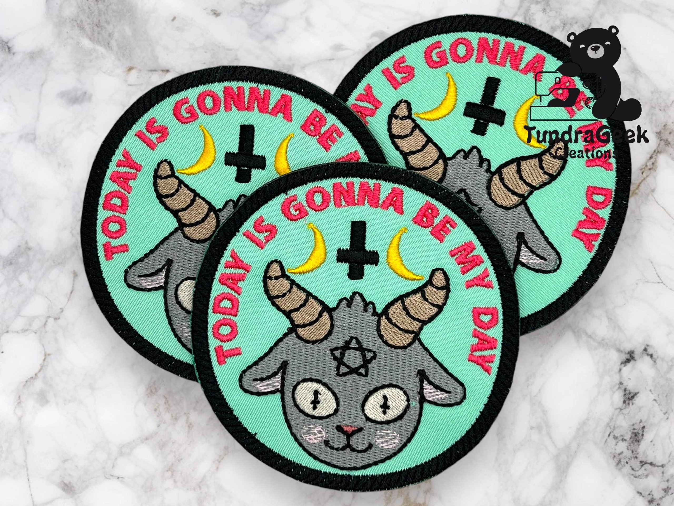 Three round embroidered patches with a goat head, two yellow crescent moons, an inverted cross, and the text TODAY IS GONNA BE MY DAY on a teal background.