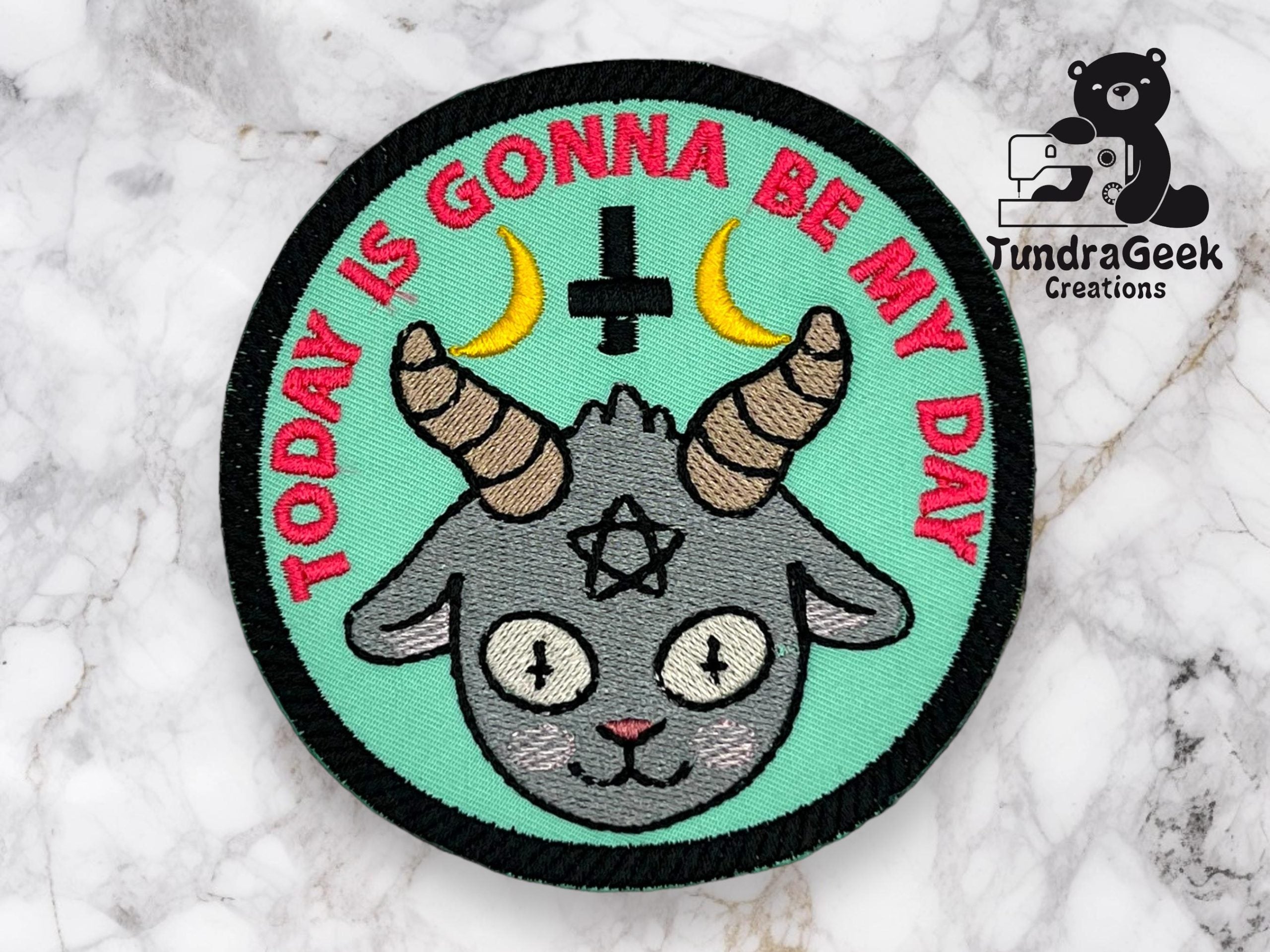 Embroidered patch with a goat head, upside-down cross, pentagram, two crescent moons, and the text TODAY IS GONNA BE MY DAY on a marble surface. TundraGeek Creations logo in corner.