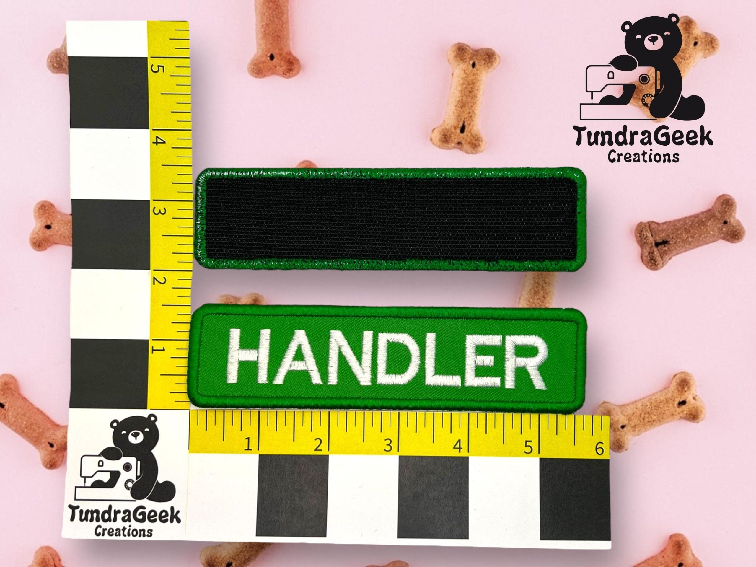 Two rectangular patches, one blank and one labeled HANDLER, are displayed with measurement scales on a pink surface with scattered dog bone treats. TundraGeek Creations logo appears twice.