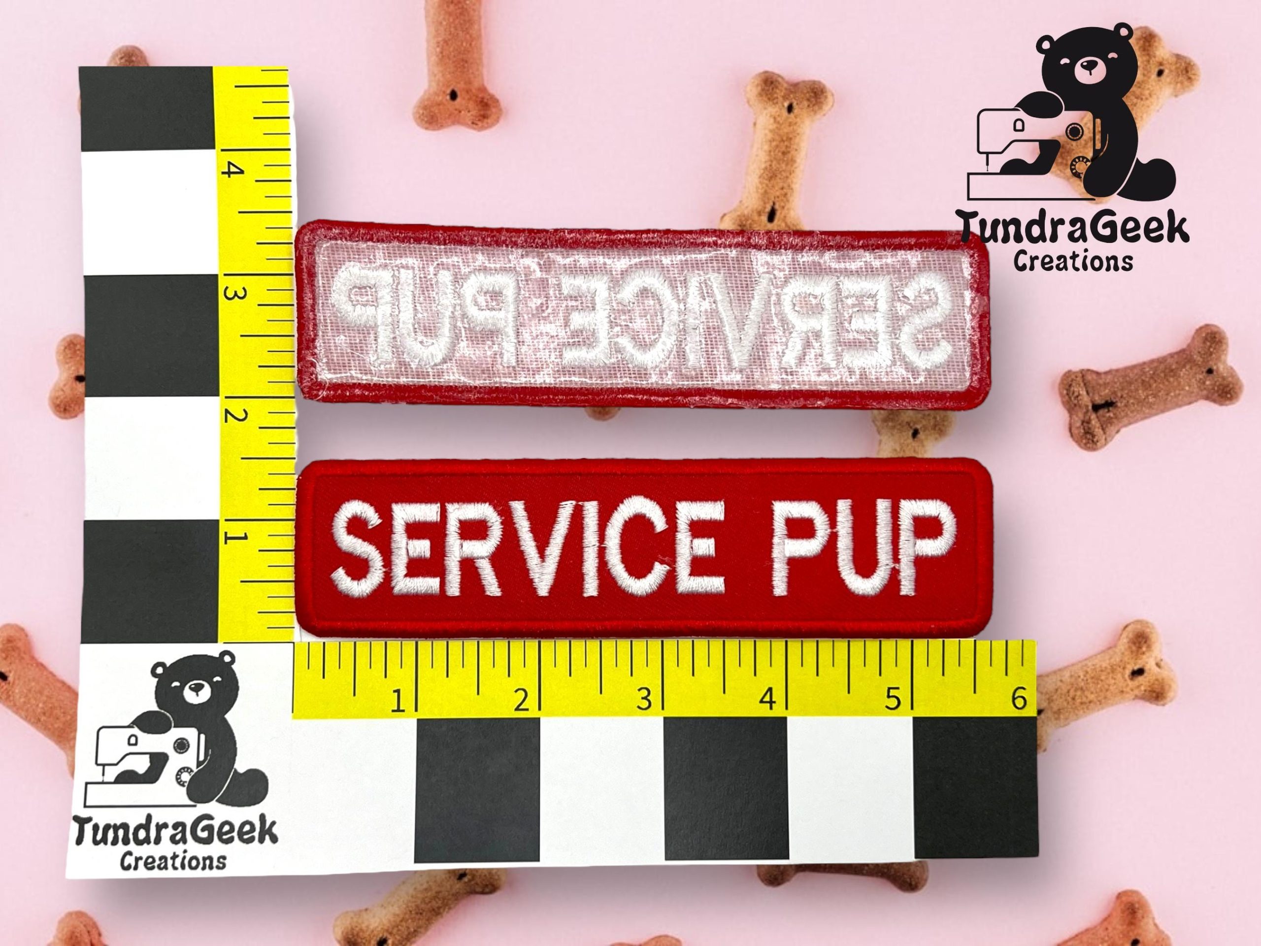Two fabric patches, one with reversed text and one reading SERVICE PUP, are placed on a pink surface with dog treats, next to a ruler for size reference.