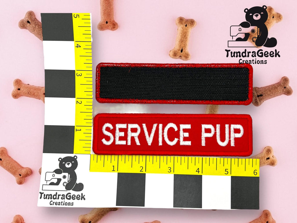 A rectangular red patch labeled SERVICE PUP and a black patch are measured with rulers, surrounded by small bone-shaped dog treats.