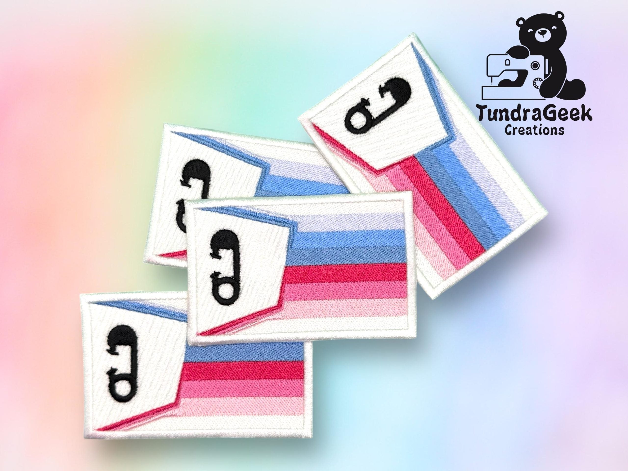 Four rectangular patches with the polyamory pride flag colors and a black pi symbol, displayed on a pastel gradient background with the TundraGeek Creations logo in the corner.