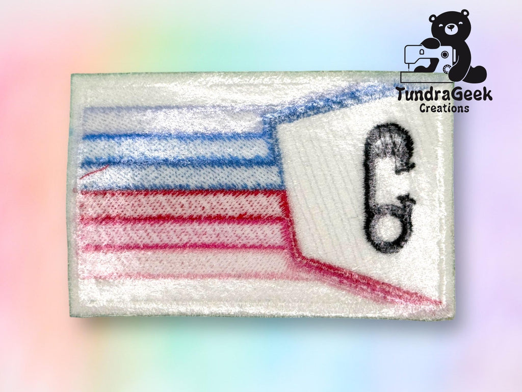 Rectangular embroidered patch with blue and red lines, a stylized phone icon, and a TundraGeek Creations logo featuring a bear with a sewing machine in the top right corner.