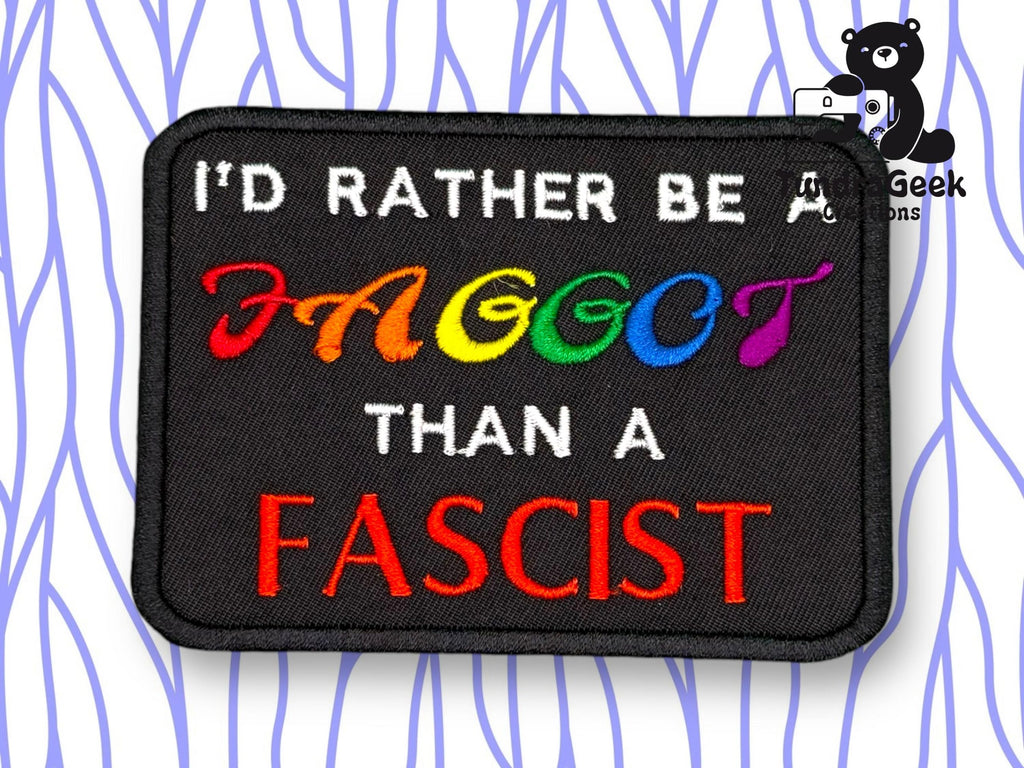 A rectangular patch with the text ID RATHER BE A FAGGOT THAN A FASCIST, with FAGGOT in rainbow colors and FASCIST in red, on a black background.