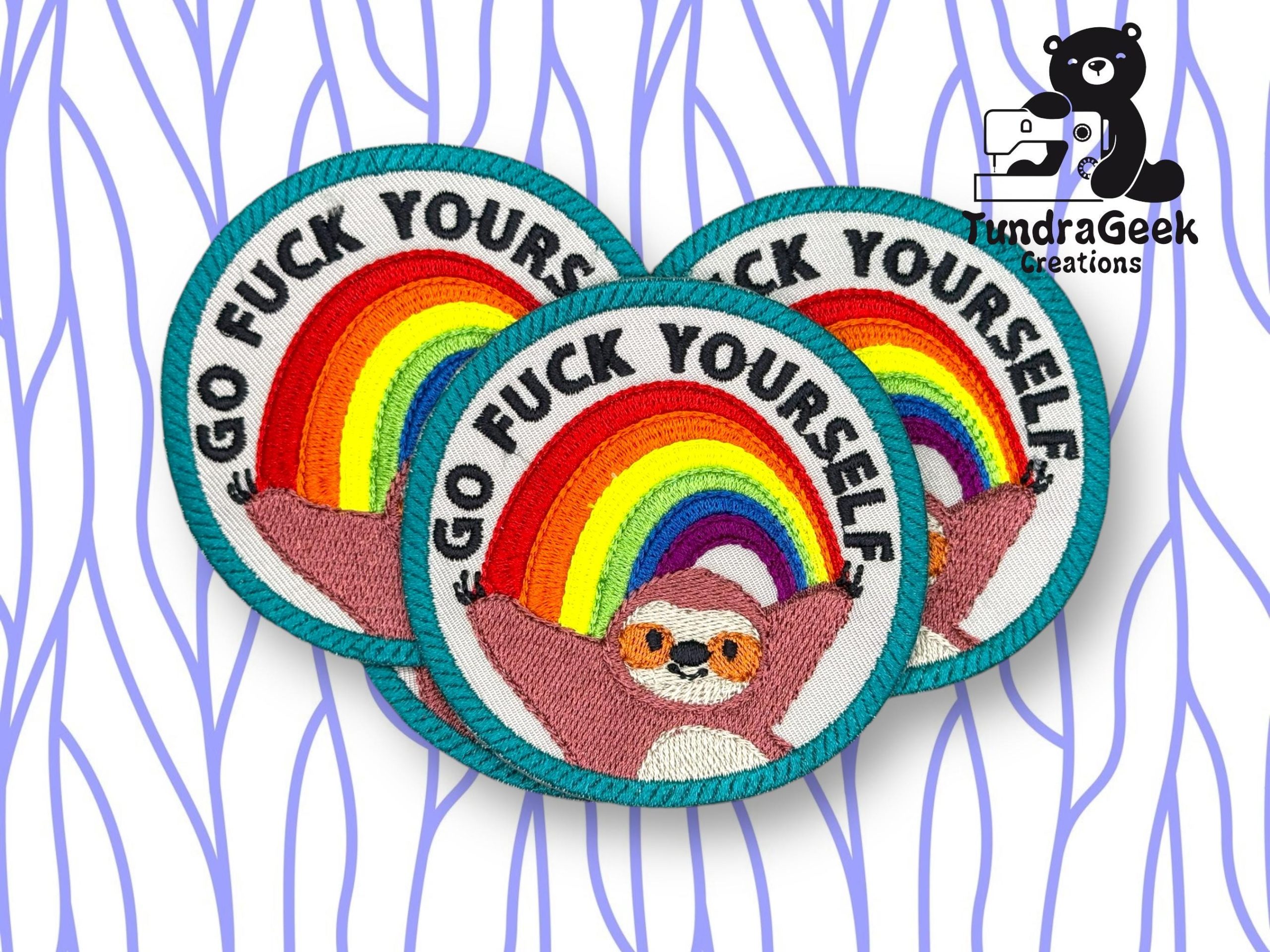 Three embroidered patches with a rainbow, a sloth, and the text Go Fuck Yourself are shown. TundraGeek Creations logo with a bear and camera is in the upper right corner.