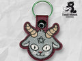 Embroidered keychain featuring a gray goat head with horns, a pentagram on its forehead, and a maroon border. TundraGeek Creations logo appears in the top right corner.