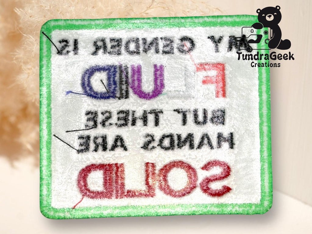 A rectangular patch with a green border and text in various colors, displayed in reverse. The patch has the TundraGeek Creations logo in the top right corner.