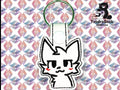 A white keychain with a cartoon cat face and red cheeks is displayed on a geometric pastel background. Logo in the corner reads TundraGeek Creations with a bear and sewing machine icon.