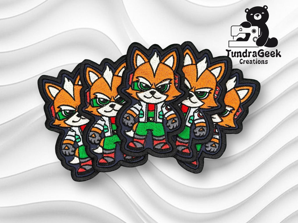 Four embroidered patches featuring an anthropomorphic fox character in a confident pose, displayed on a white textured background with the TundraGeek Creations logo in the top right corner.