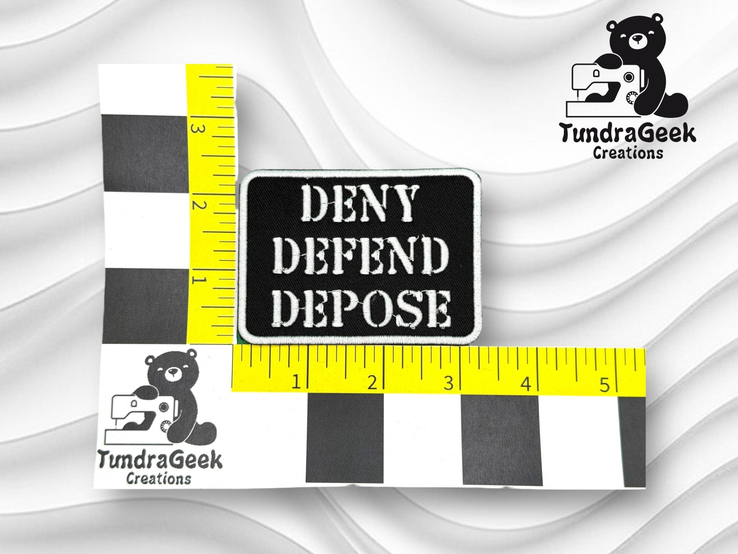 A rectangular patch with the words DENY DEFEND DEPOSE is shown next to rulers for scale, featuring TundraGeek Creations bear logos.