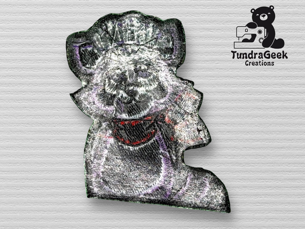 Embroidered patch of a raccoon wearing a chef hat and red scarf, with TundraGeek Creations logo featuring a bear and sewing machine in the upper right corner.