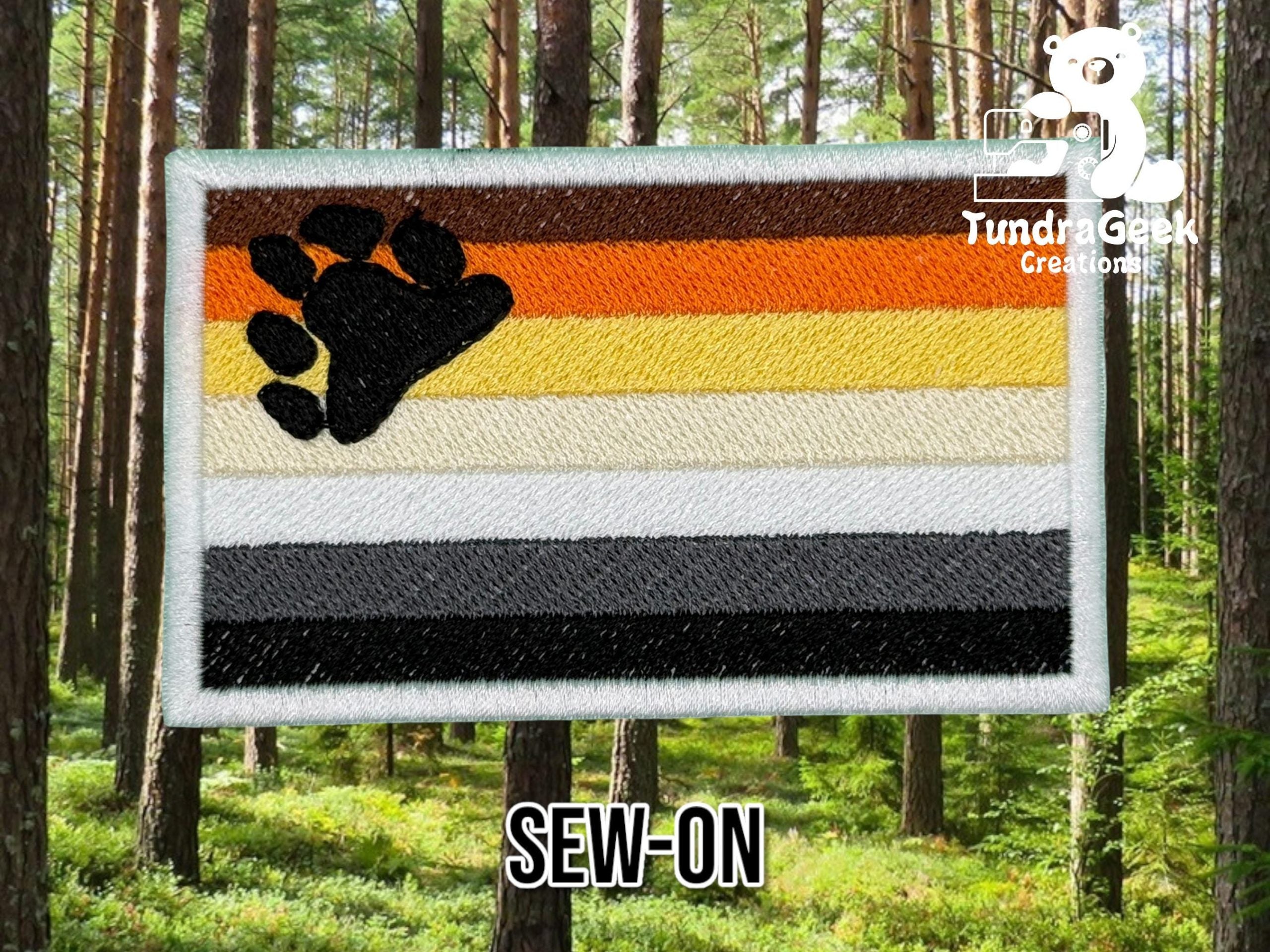 A rectangular embroidered patch with brown, orange, yellow, white, and black stripes and a black paw print, labeled SEW-ON, is shown against a forest background.
