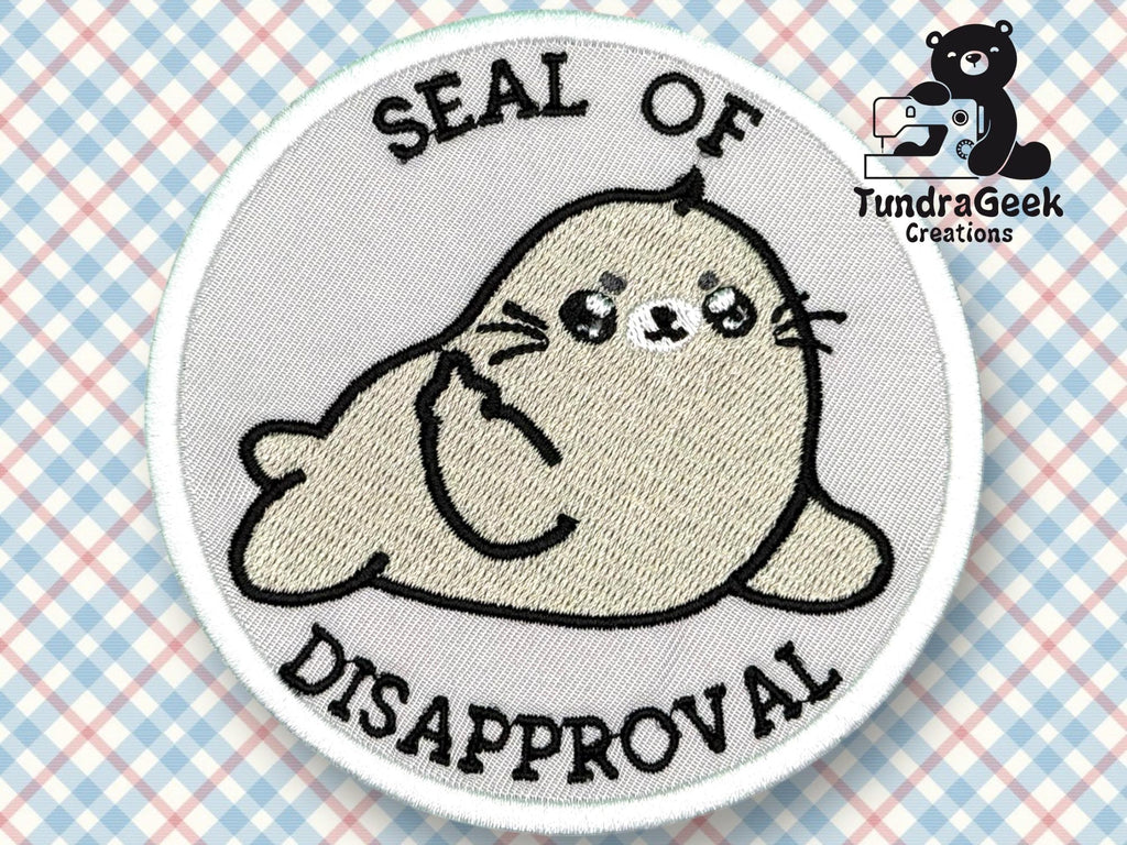 An embroidered patch shows a cartoon seal giving a middle finger, with the text SEAL OF DISAPPROVAL above and below the seal.