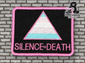 Rectangular patch with a pink-bordered triangle in trans pride colors and the words SILENCE=DEATH below, on a black background. Brick wall backdrop, TundraGeek Creations logo in corner.