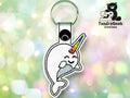 Keychain featuring an embroidered cartoon narwhal with a rainbow horn, set against a soft-focus, colorful background. TundraGeek Creations logo appears in the top right corner.