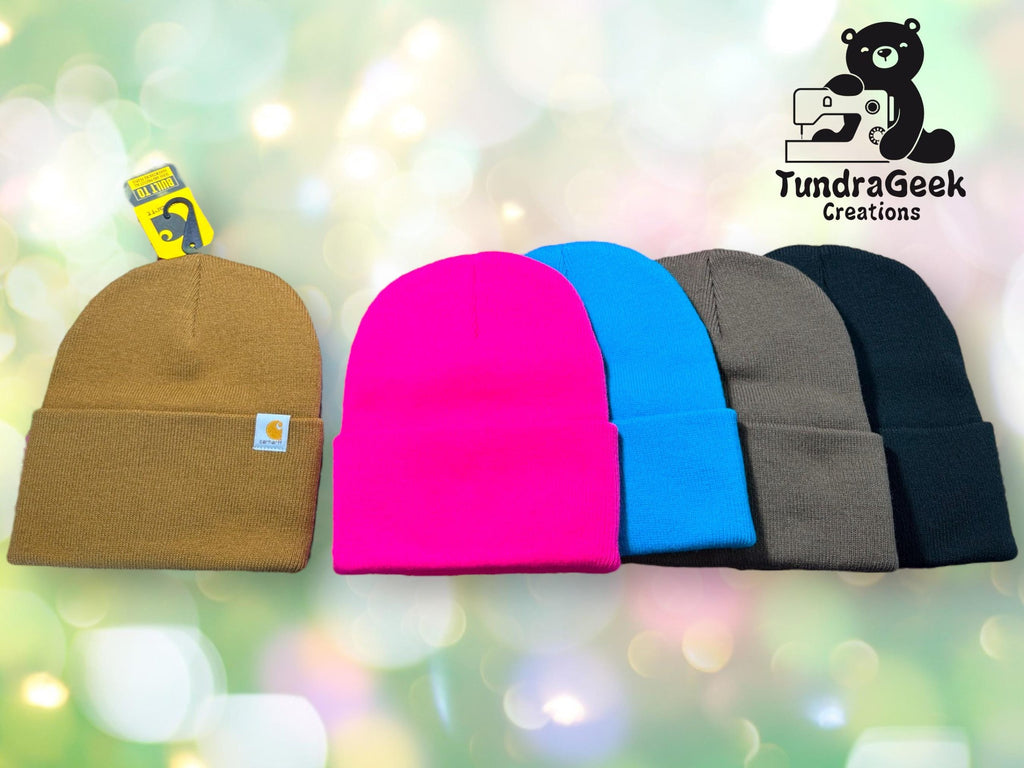 Five beanies in brown, pink, blue, gray, and black are displayed side by side. A TundraGeek Creations logo with a bear and sewing machine is in the top right corner.