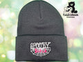 A dark gray knit beanie with Spooky Bitch embroidered in white and pink over a spiderweb design. Logo for TundraGeek Creations with a bear and sewing machine is in the top right corner.