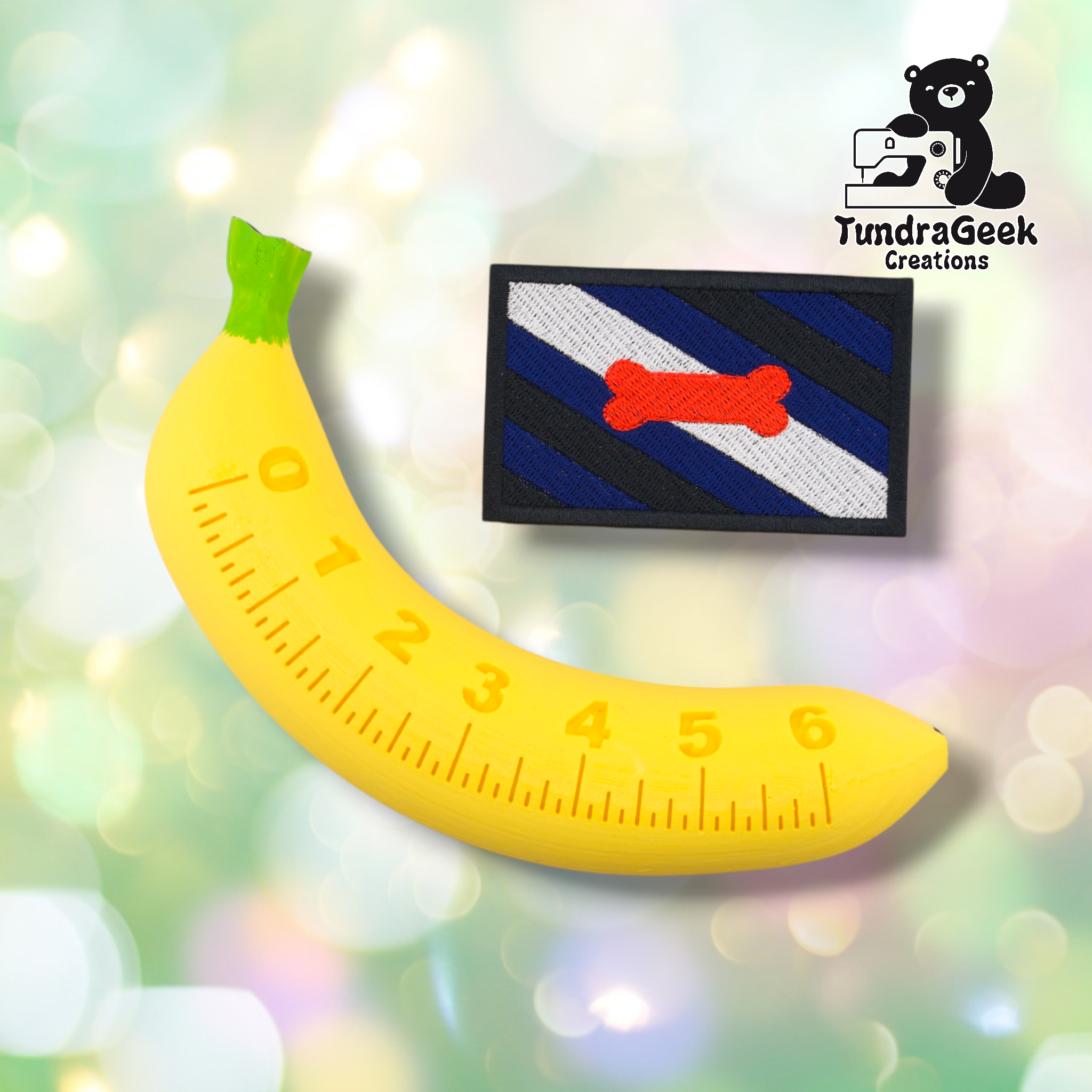 A yellow banana-shaped ruler (0–6) is beside the Pup Pride Flag Patch by TundraGeek Creations, a rectangular embroidered patch with diagonal blue, black, and white stripes plus a red bone. Logo appears in the corner.